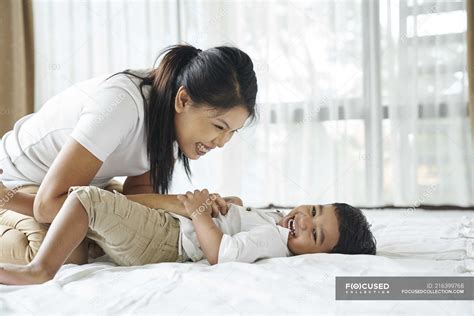 Asian Mother Bonding With Her Son On The Bed Enjoyment Love Stock