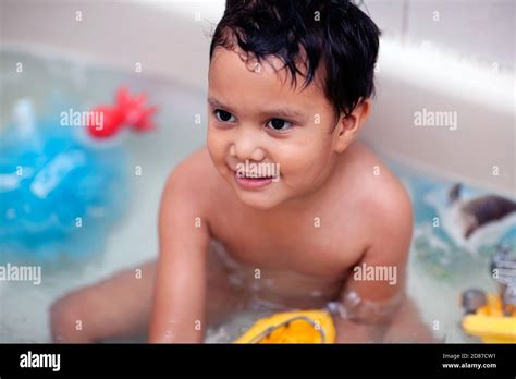 Bath Time With A Boy Sitting In The Tub And Playing With Toddler Water