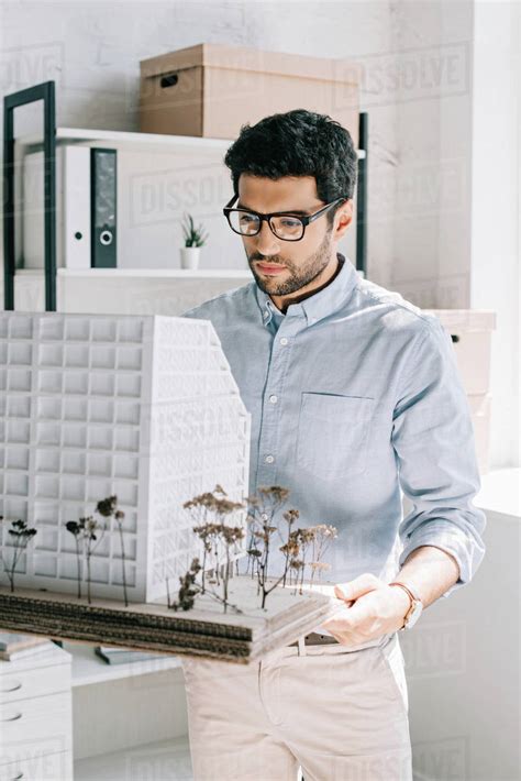 Handsome Architect Holding And Looking At Architecture Model In Office