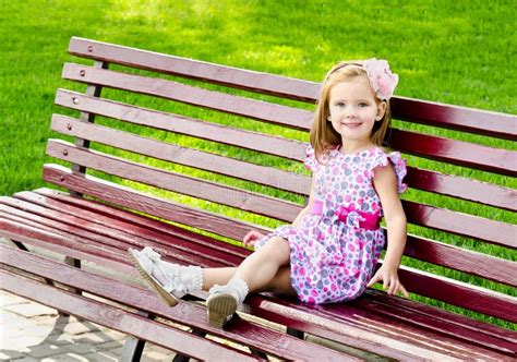Outdoor Portrait Of Little Girl Sitting On A Bench Stock Photos Image