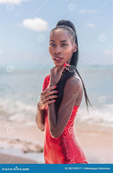 Portrait Of Beautiful Caribbean Adult Teen In Barbados Wearing Red Bikini And Standing On A