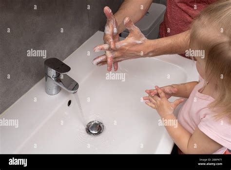 El padre le muestra a su hijo cómo lavarse las manos correctamente Fotografía de stock Alamy