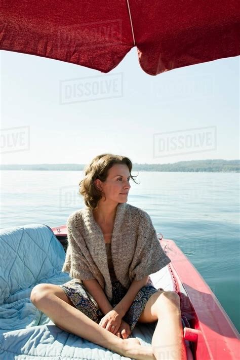 Woman Relaxing In Boat On Still Lake Stock Photo Dissolve