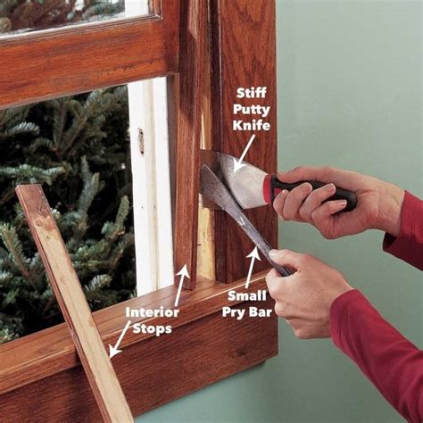 A Person Using A Window Sealer To Fix A Window Pane With Wood Trim