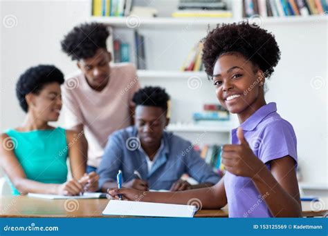Successful African American Female Student Learning At Desk At School