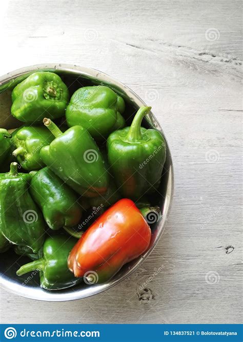 On The Table In A Cup A Lot Of Green Peppers And One Red Photo For The