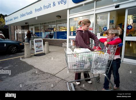 Two Children With Shopping Trolley Of Food Outside Co Op Supermarket