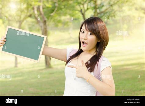 Young Asian College Girl Student Standing On Campus Lawn Hands Holding