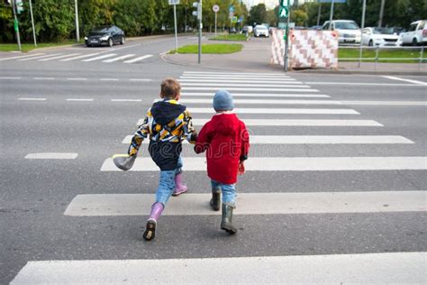 Children Cross The Road Through A Pedestrian Crossing Stock Image