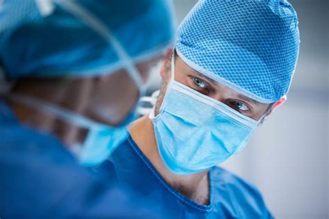 Surgeons Interacting While Performing Operation Photo Free Download
