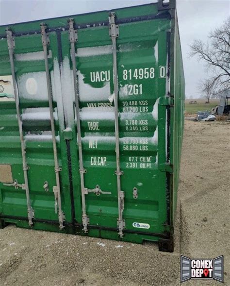 A Green Shipping Container Sitting On Top Of A Dirt Field