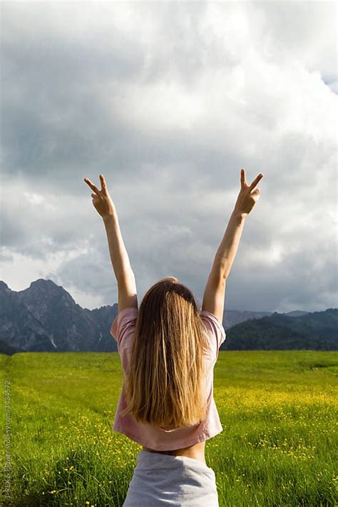 Woman On Field Gesturing Two Fingers By T Rex And Flower For Stocksy