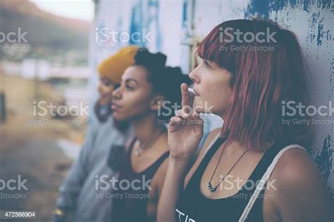 Grungy Teen With Pink Hair Hanging Out Smoking With Friends Stock Photo