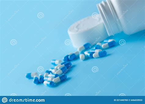 Many White And Blue Capsules Pill Spread On Blue Background Antibiotics