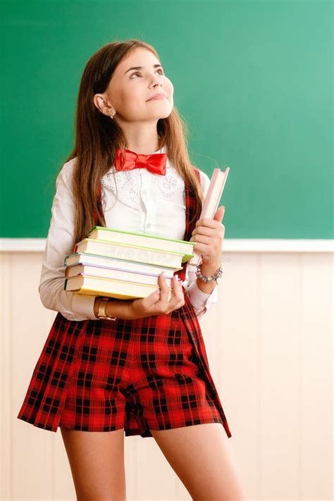Beautiful Young School Girl In School Uniform Standing With Books In