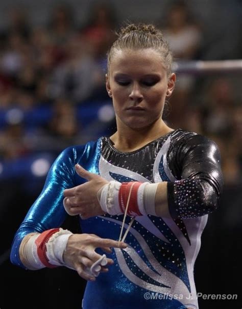 A Woman In A Blue And White Gymnastics Outfit Holding Her Hands Out To The Side