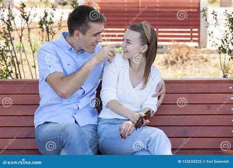 Happy Young Couple In Love Sitting On A Park Bench Stock Image Image