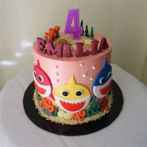 A Pink Birthday Cake With Colorful Decorations On Its Top And The