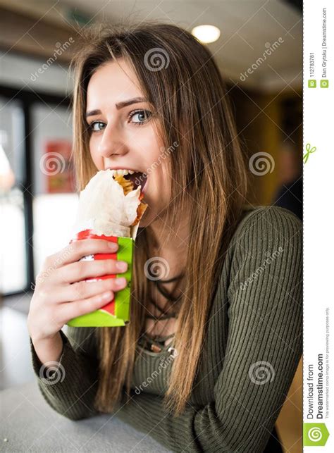 Young Hungry Woman Sitting In A Restaurant Eating An Doner Hand Hold
