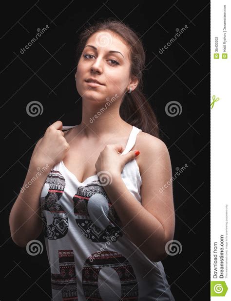 sexig kvinna i den vita singleten som poserar mot svart bakgrund arkivfoto bild av framsida
