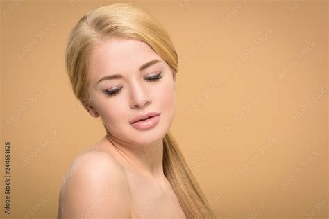 Naked Blonde Woman With Long Shiny Hair Looking Down Isolated On Beige