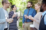 Group of people with drinks talking outside - Stock Photo - Dissolve