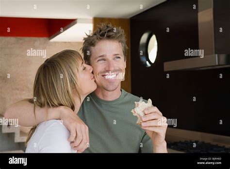 Woman Kissing Man On Cheek Stock Photo Alamy