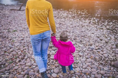 Mother And Daughter Walking At Riverside Stock Photo Download Image