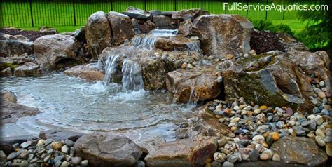 Waterfall With Pooling Area Cascading Into Koi Pond Designed And