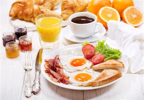 Breakfast With Fried Eggs Croissants Juice Coffee And Fruits Stock