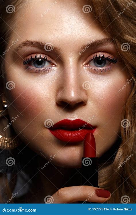 Beautiful Girl With Red Lips And Classic Makeup And Curls With Lipstick