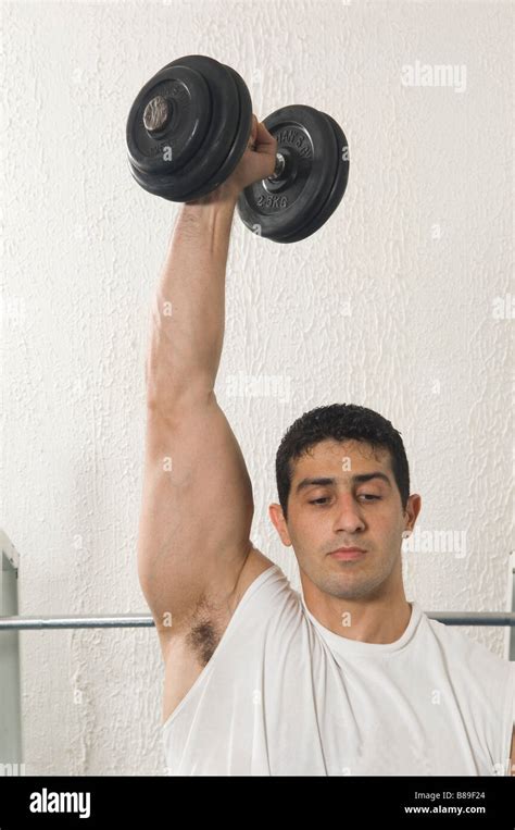 Muscular Man Lifting Free Weight Dumbbell In The Gym Stock Photo Alamy