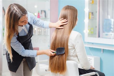 Master Hairdresser Woman Combing Hair Of Client In Chair Beauty Salon