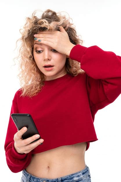 Premium Photo Upset Curly Girl With A Phone In Her Hands Holds Her Hand On Her Head
