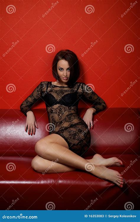 Jeune Femme Dans La Robe Noire Se Reposant Sur Le Sofa Image Stock Image Du Fille Pattes