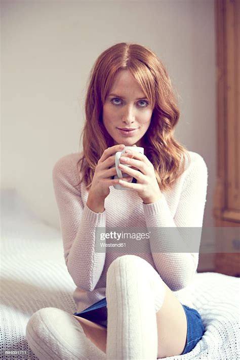 Portrait Of Redheaded Woman With Cup Sitting On Bed Photo Getty Images