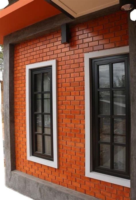 An Orange Brick Building With Two Black Windows