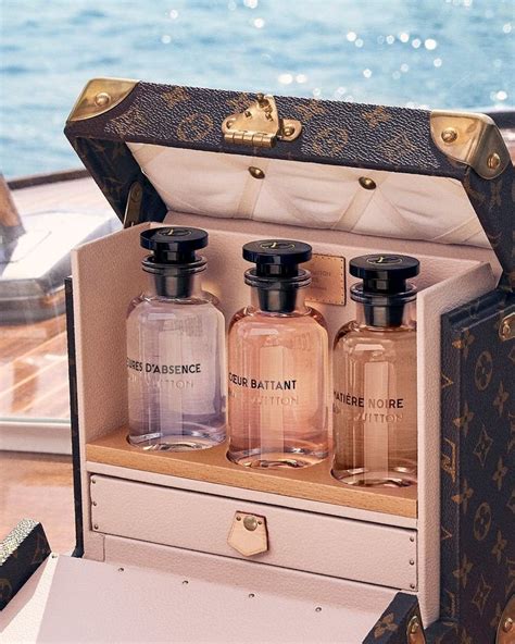 Three Bottles Of Perfume Sitting In An Open Suitcase On A Table Next To