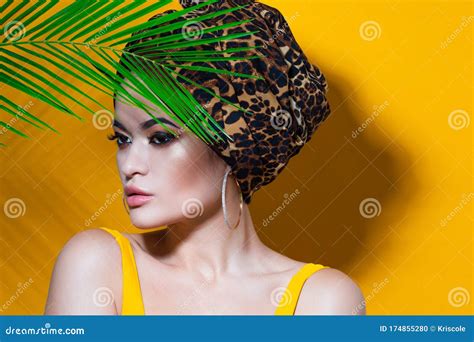 An Attractive Young Woman In A Stylish Turban Made Of Leopard Print
