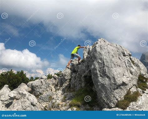 Man Climbing Up A Steep Hill With Rocks Below Him In Porec Austria