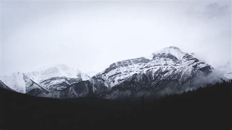 Clouds And Fog Over Snowy Mountain Peaks In The Winter Mist Over Banff