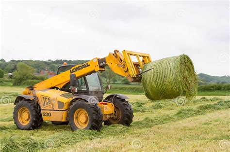 Loader Tractor Moving A Round Bale From Field Editorial Photography