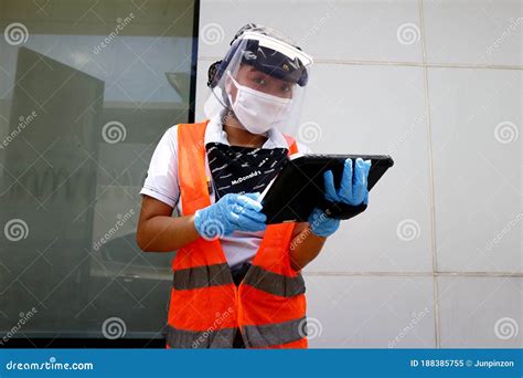 Employee Wearing Ppe Take Orders From Customers At The Drive Thru Of A