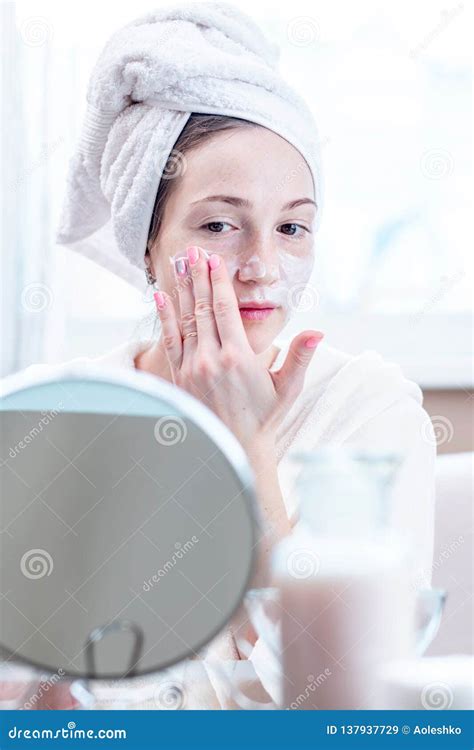Beautiful Happy Woman Applying Cream On Face Moisturizing The Skin