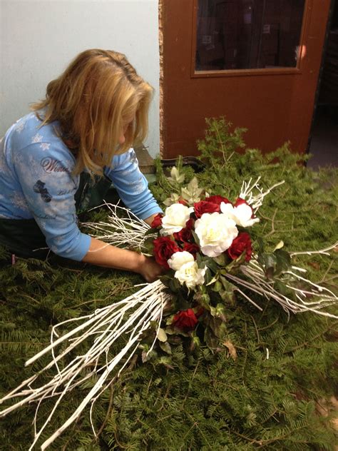 (flower arrangement) a decorative arrangement of flowers. This cross was custom created for a grave blanket ...