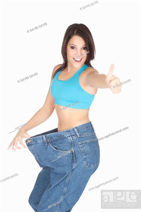 Woman Showing Weight Loss By Wearing An Old Pair Of Jeans Stock Photo