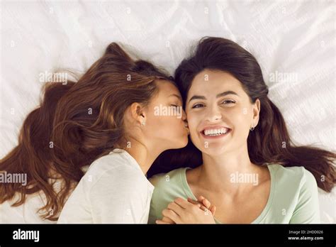 La hija pequeña despierta a su feliz mamá con un beso en la mañana del Día de la Madre