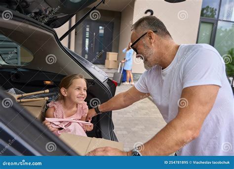 Kleines Mädchen Sitzt Im Auto Und Sieht Dem Vater Zu Wie Er Sich Die Kiste Nimmt Stockbild