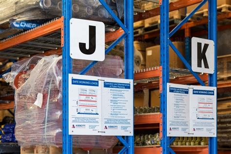 Learn about pallet racking basics with this free material handling equipment guide from the top material handling pros at sjf.com. Image of Warehouse shelving and safety signs - Austockphoto