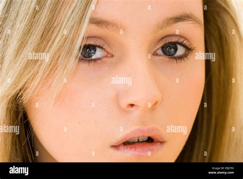 caucasian blonde blue eyed teenage girl close up of face looking at viewer with mouth partly